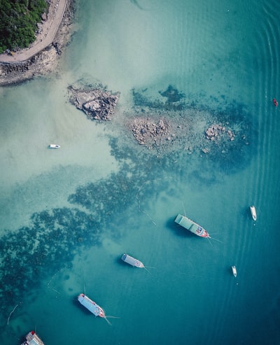 航拍的照片船锚定在海滩附近的浅水白天
